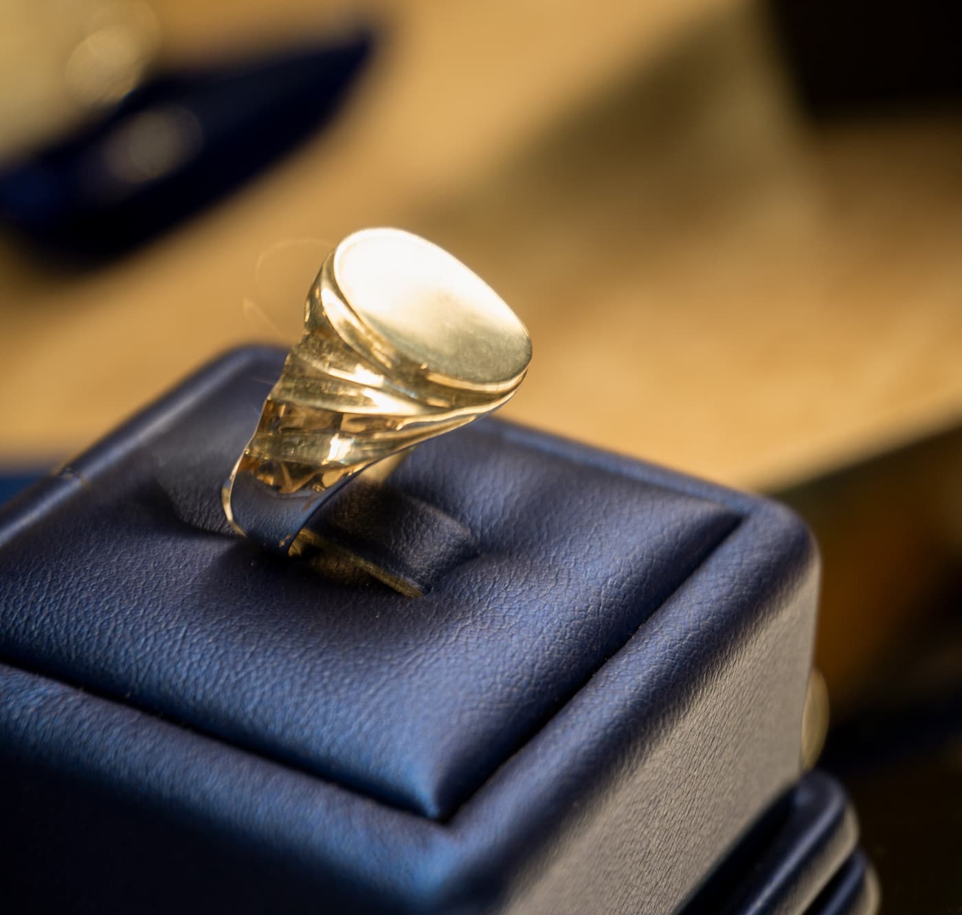Custom signet ring displayed on a jewellery presentation cushion